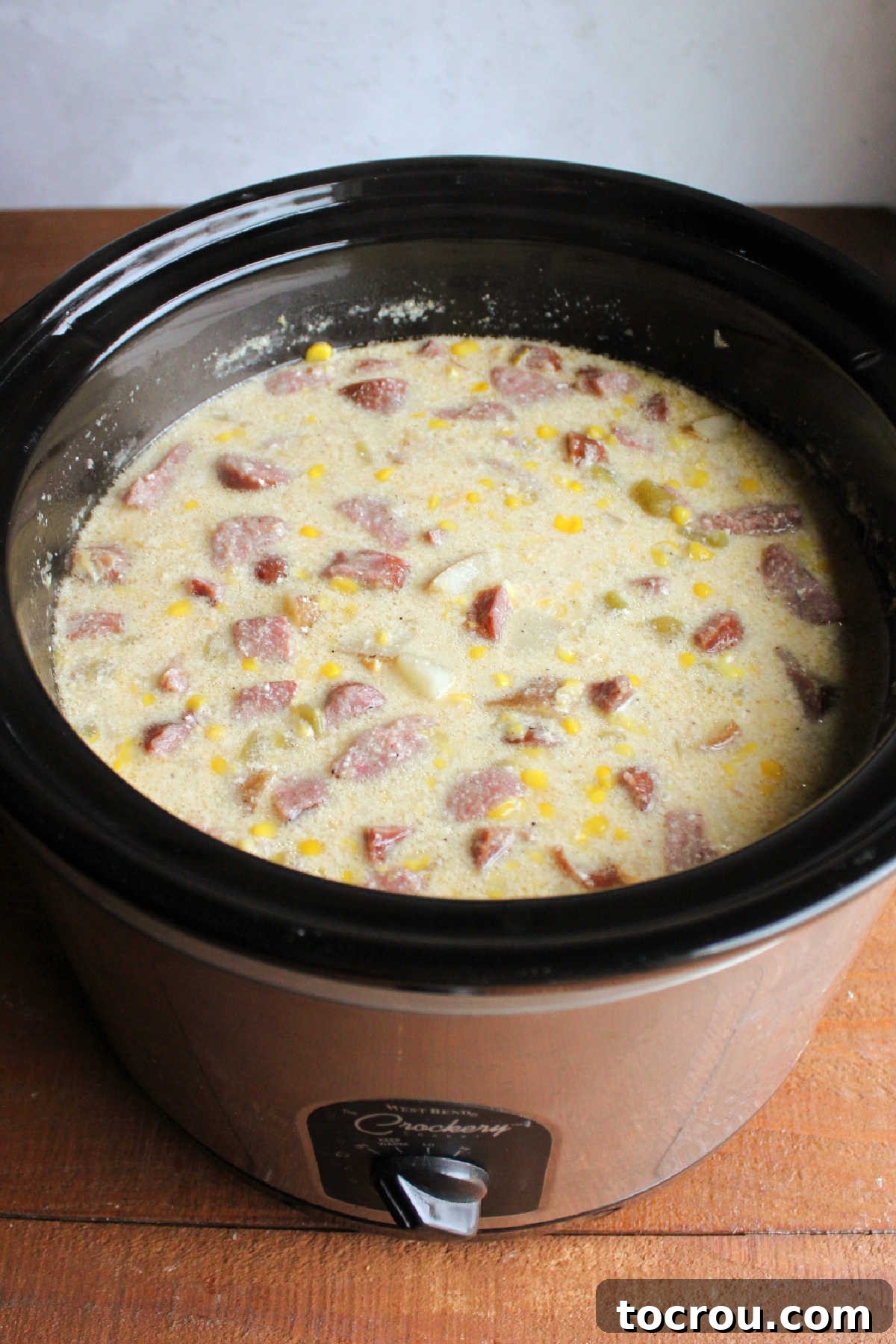 Slow cooker filled with cooked chowder showing creamy broth and lots of chunks.