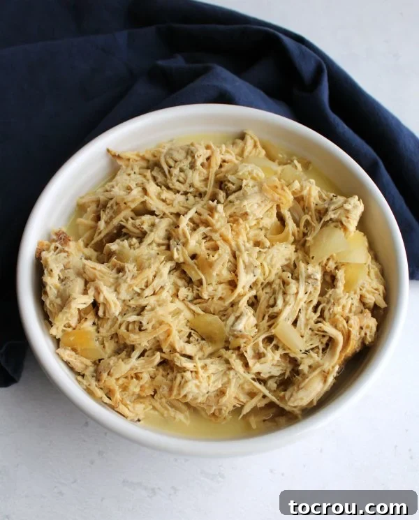 Shredded Lemon Yogurt Chicken Filling Bowl of shredded slow-cooked lemon and yogurt chicken, showcasing its tender texture and vibrant color.