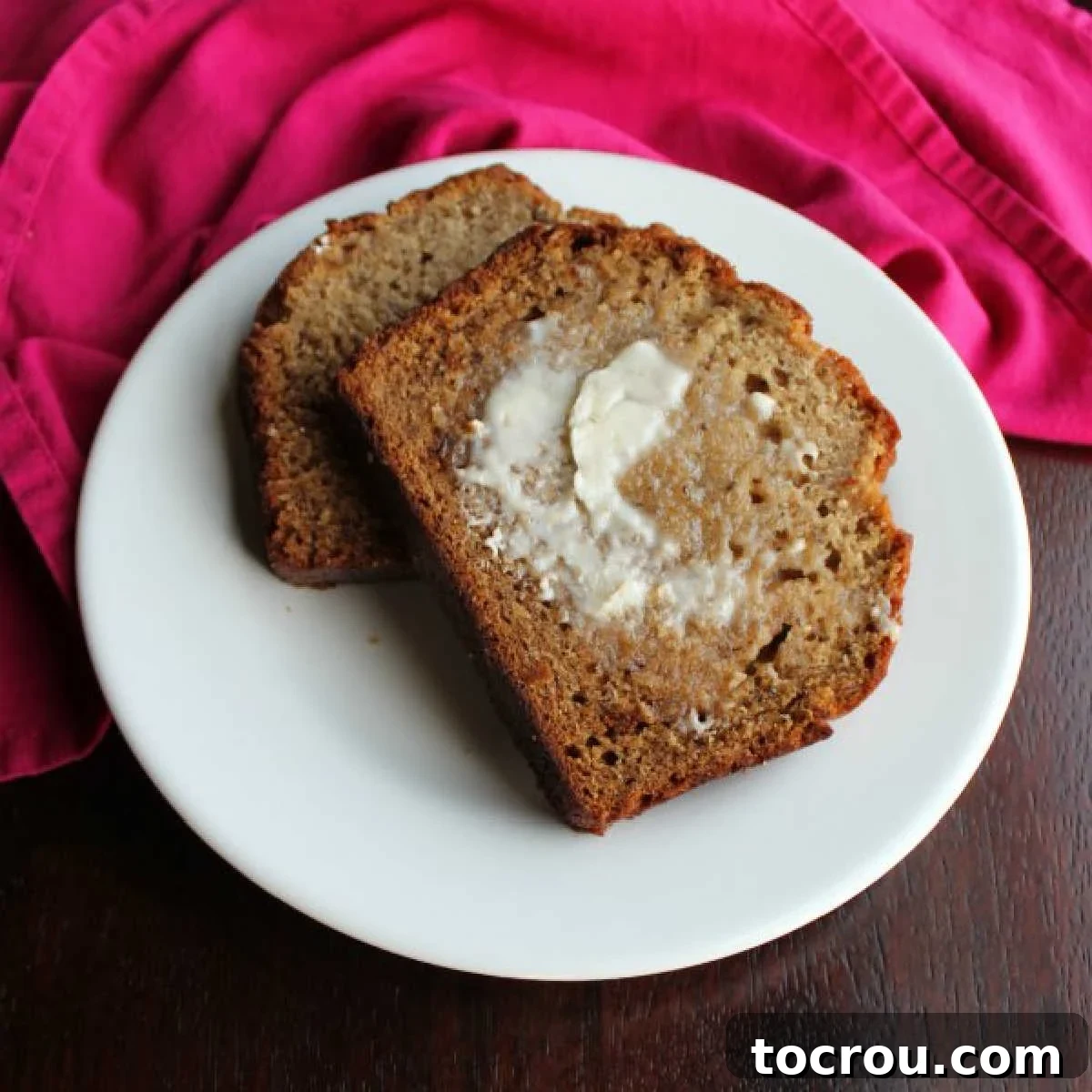 Slices of golden-brown banana bread with a rich, moist texture, gently buttered and ready to be enjoyed. The perfect comforting treat for any time of day.