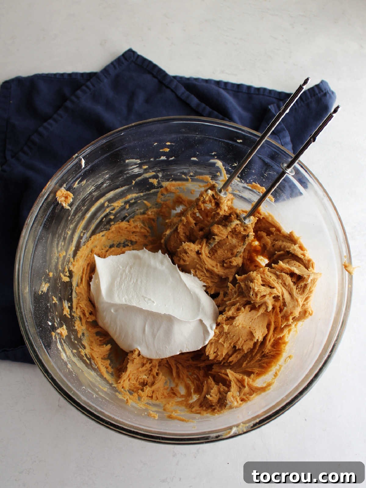 Gently folding Cool Whip into the peanut butter and cream cheese mixture.