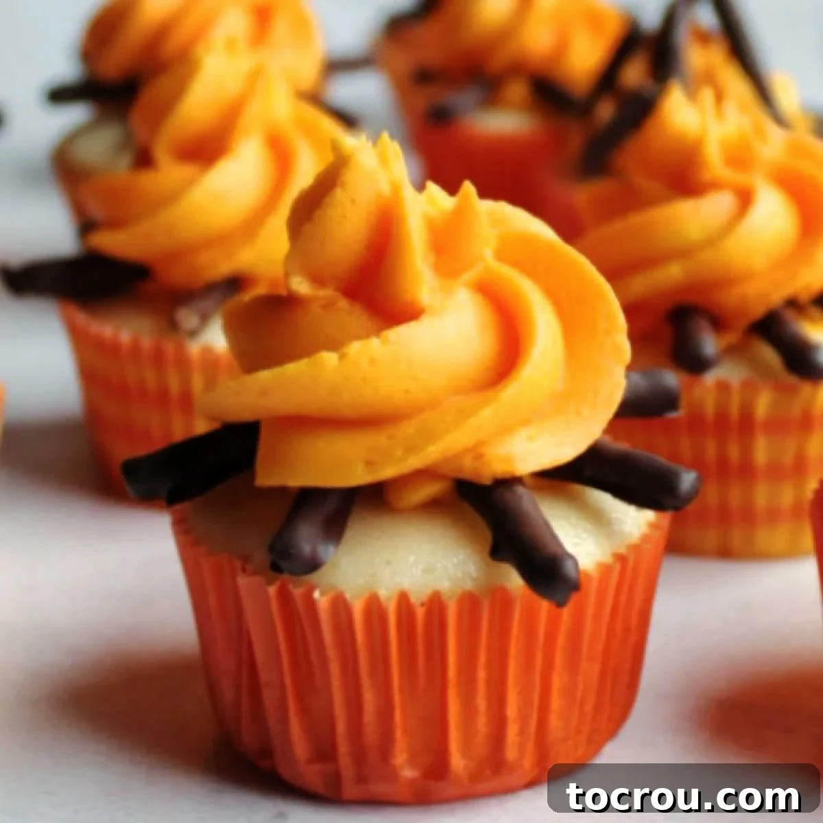 Close up of cupcake decorated with chocolate covered pretzel and buttercream campfire.