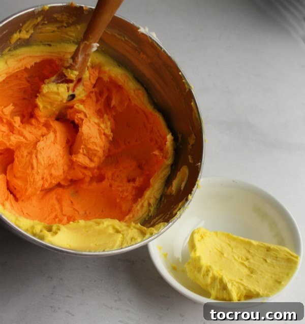 bowls of yellow and orange buttercream frosting ready to be piped onto cupcakes.