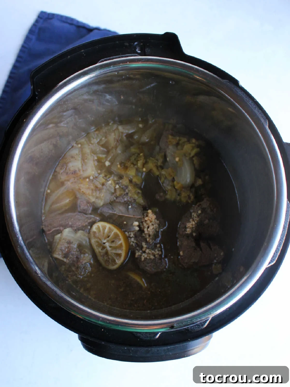 Instant Pot full of cooked venison barbacoa, perfectly tender and ready to be shredded and served.