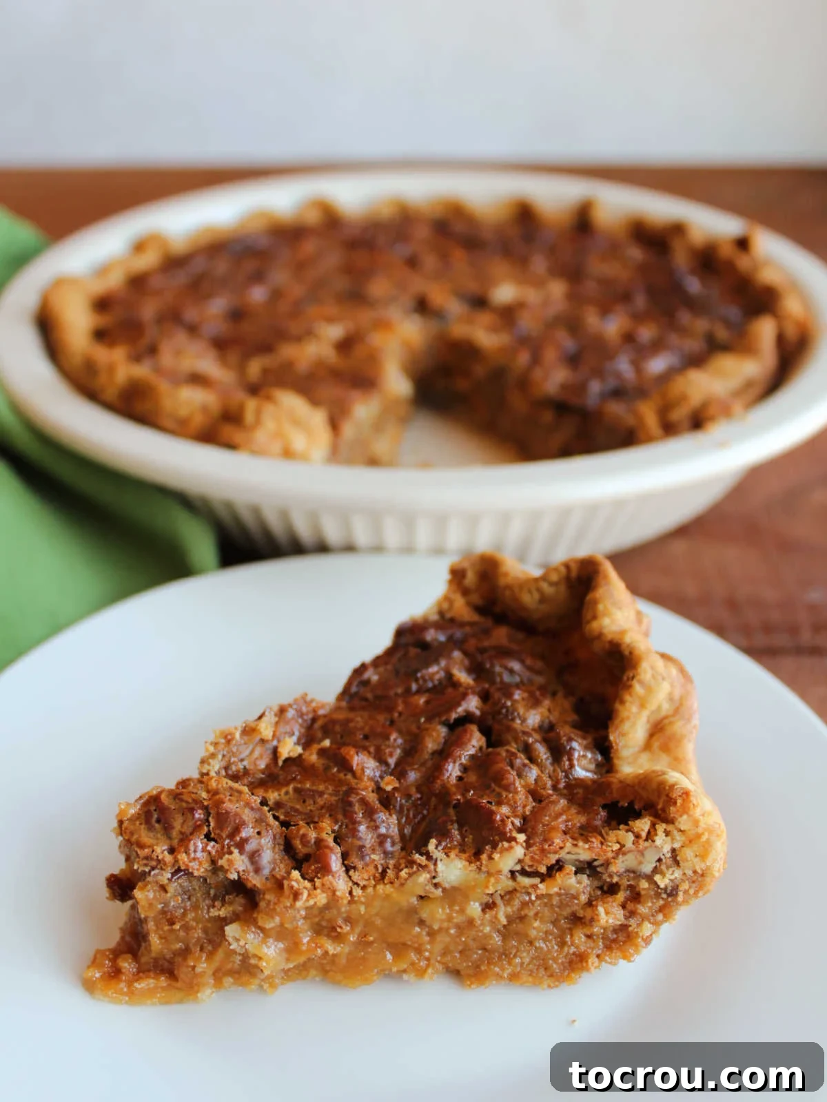 Golden Caramel Pecan Delight 9 Slice of caramel pecan pie with thick caramel filling and lots of pecans on top in flaky pastry shell, ready to eat.