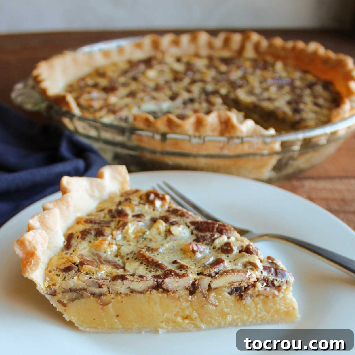 Slice of pie showing smooth sweetened condensed milk and brown sugar filling topped with toasted pecans.