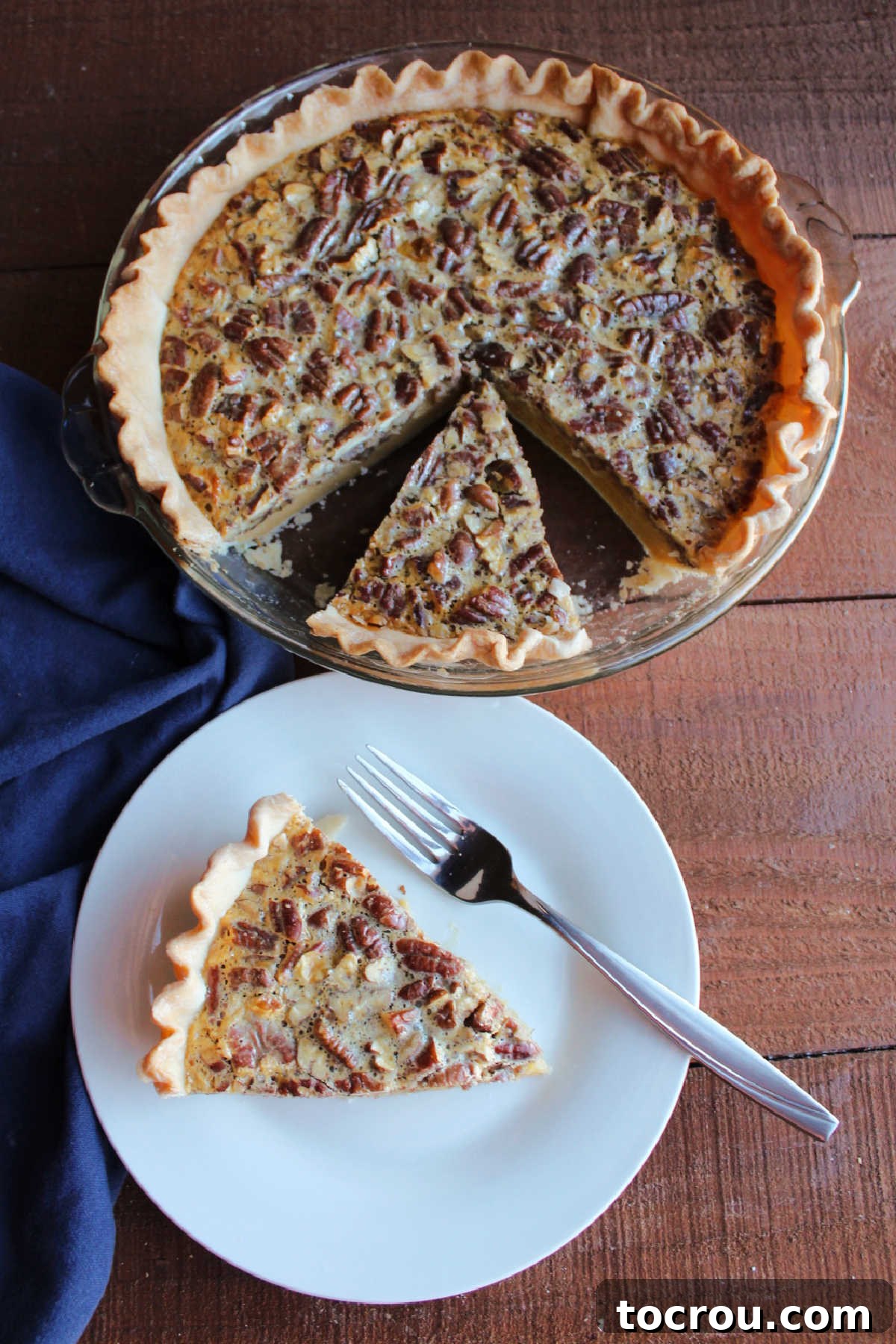 Sliced of sweetened condensed milk pecan pie served on small dessert plate with remaining pie in the background.