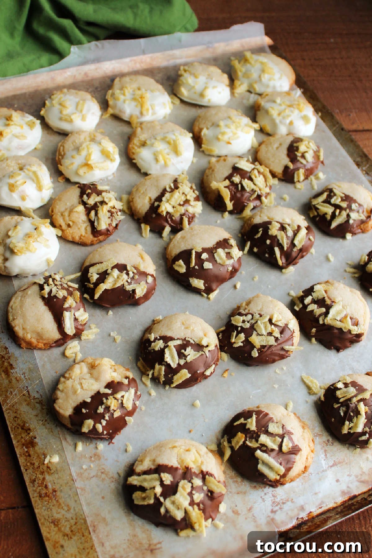 Grandmas Golden Crunch Cookies 9 Potato chips cookies with half of each cookie coated in chocolate or white chocolate and topped with more potato chips on wax paper.