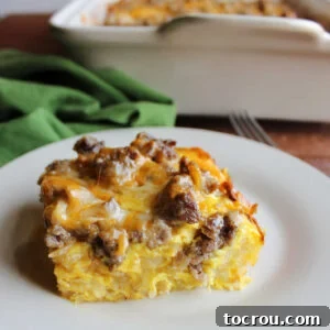 Piece of hashbrown egg casserole with sausage and cheddar cheese ready to be eaten.
