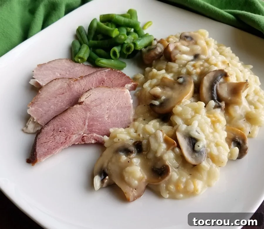 Classic Mushroom Risotto Plate of creamy mushroom risotto garnished with fresh herbs, alongside ham and green beans