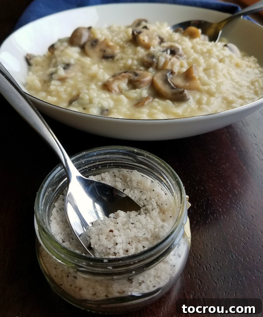 Mushroom Risotto with Truffle Salt Bowl of creamy mushroom risotto served with a container of truffle salt on the side.