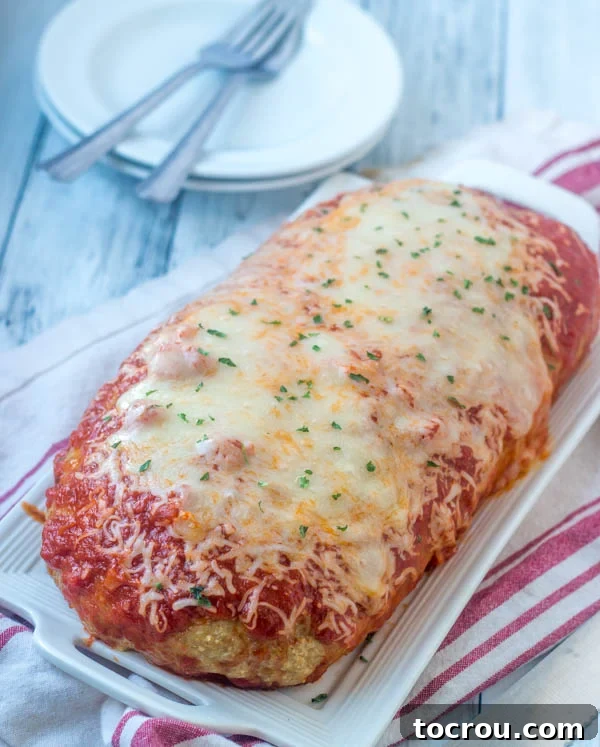 Homemade Chicken Parm Meatloaf Whole chicken parm meatloaf topped with marinara and melted cheese, ready to be sliced and served.