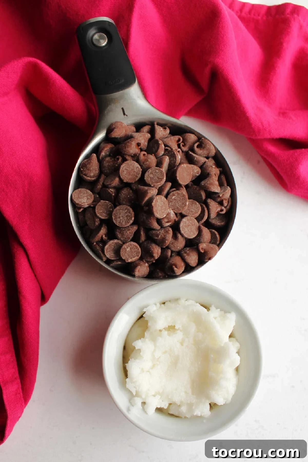 Simple Magic Shell Ingredients Two ingredients for magic shell: chocolate chips and solid coconut oil in separate bowls.