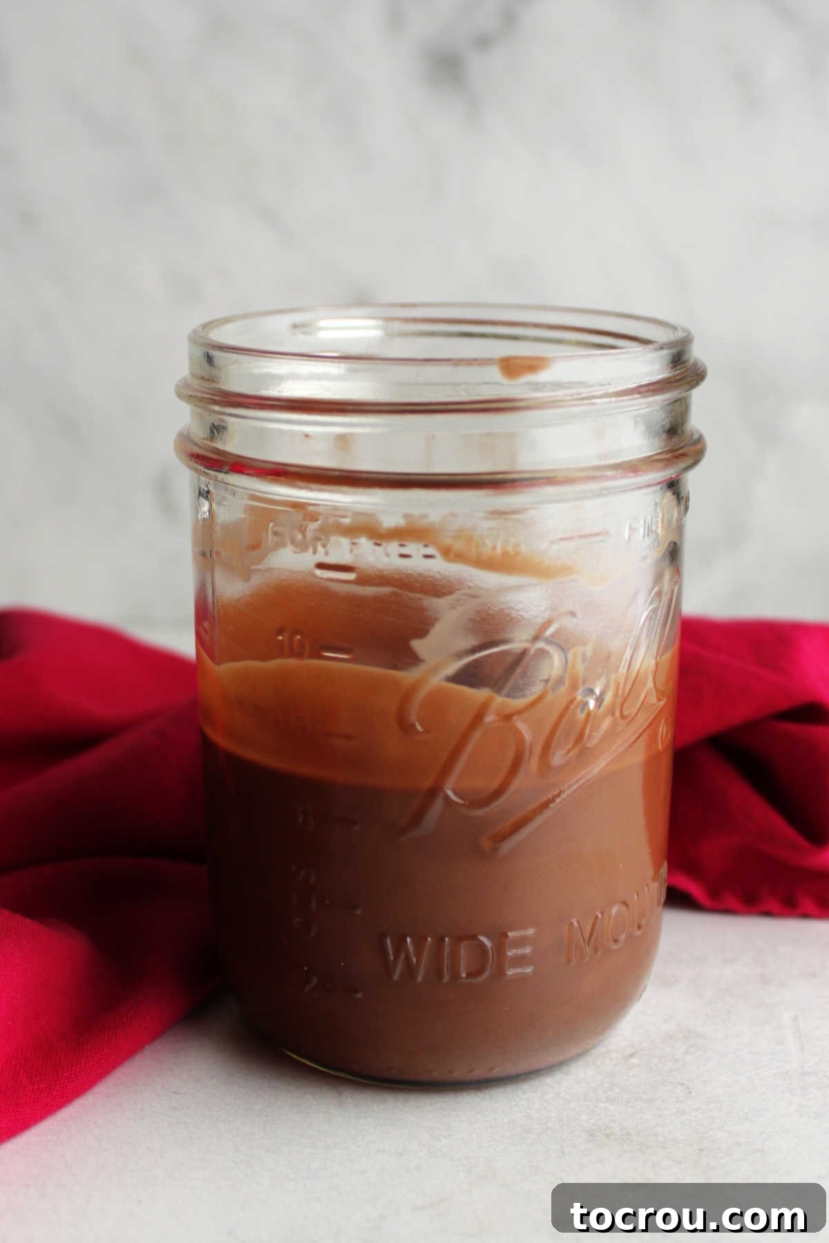 Melted Chocolate Magic Shell Ready to Use Glass jar filled with warm, smooth chocolate magic shell after melting.