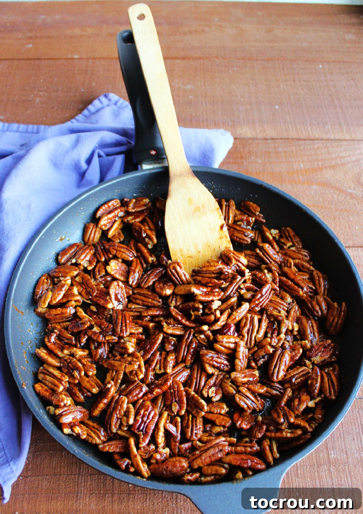 Pecans Coated in Spices Pecans thoroughly tossed in the butter and spice mixture, prepared for baking in the oven.
