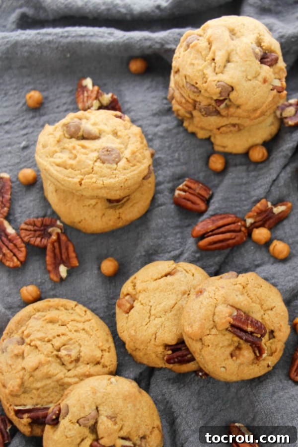 Beautifully stacked Turtle Cookies, showcasing their rich, golden-brown edges and inviting texture, ready for a delicious indulgence. Each cookie promises a blend of chocolate, caramel, and pecans.
