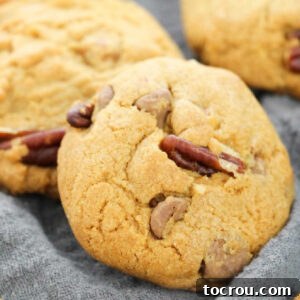 Close-up of freshly baked Turtle Cookies, showcasing melted chocolate chips, gooey caramel, and crunchy pecan pieces. These rich, chewy cookies are a delightful twist on a classic.