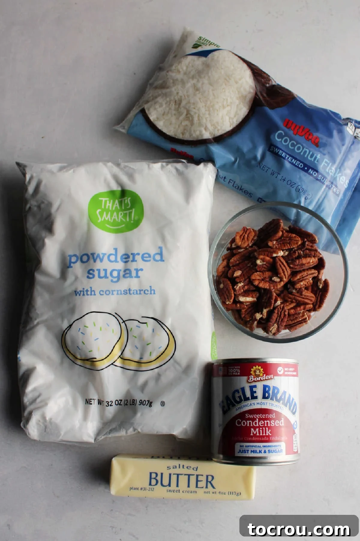 Ingredients including butter, condensed milk, powdered sugar, coconut and pecans ready to be made into bon bon filling.