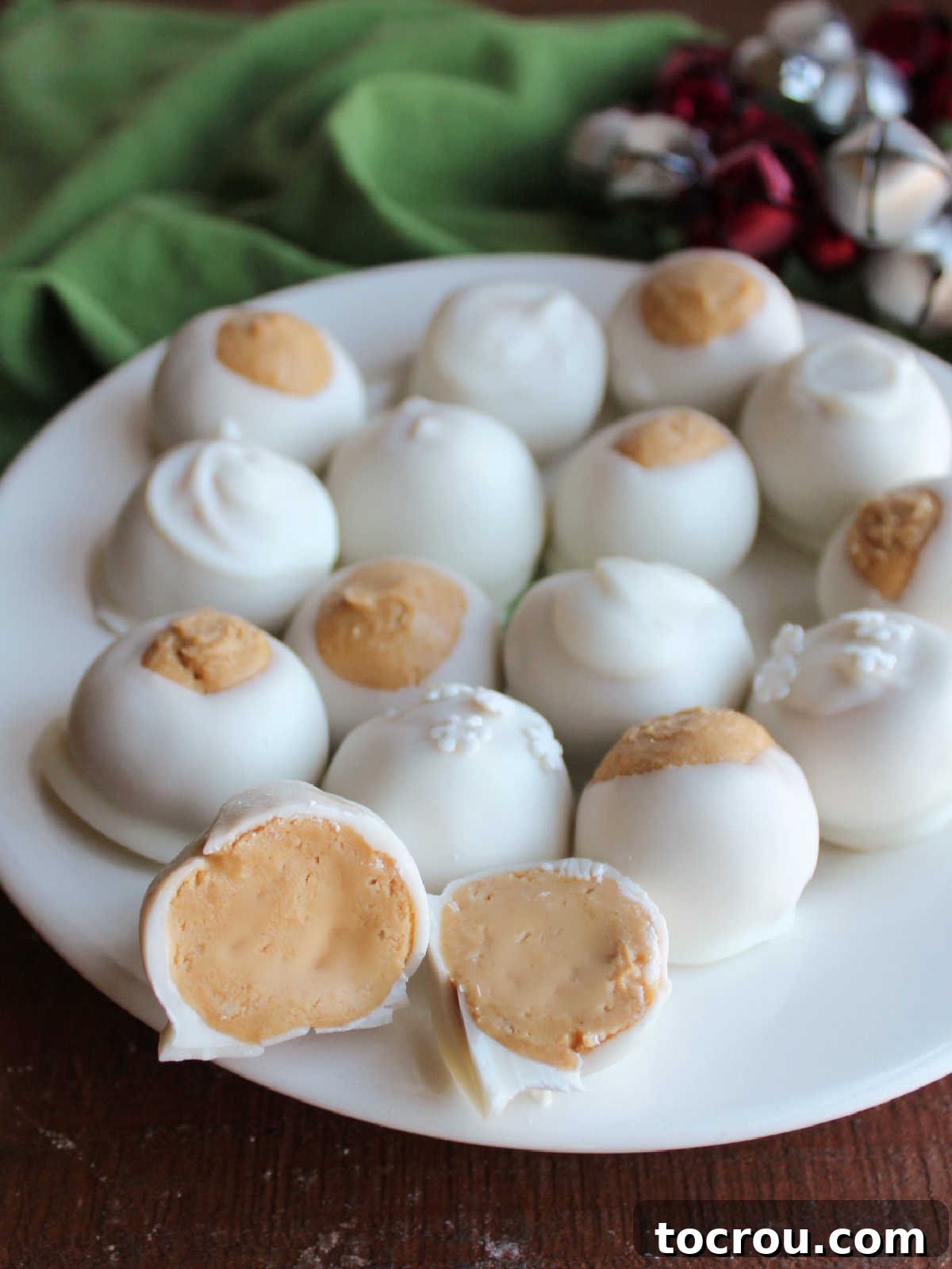An inviting plate showcasing an assortment of white chocolate snowballs and buckeyes, highlighting their creamy peanut butter filling and contrasting white chocolate exteriors, ready for serving.