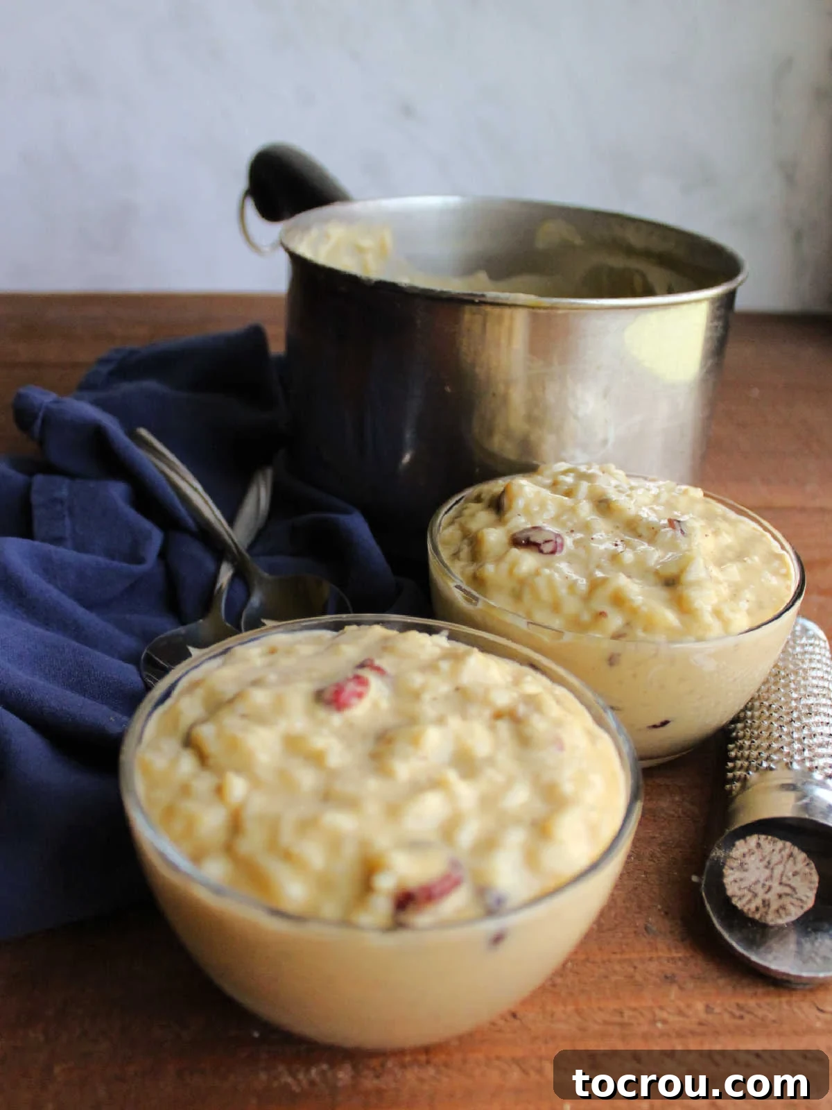 Serving Evaporated Milk Rice Pudding Bowls of rice pudding with evaporated milk in front of saucepan of remaining pudding.