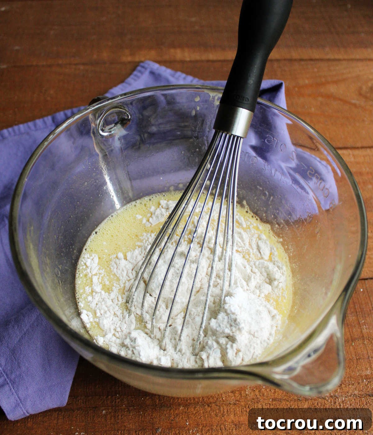 Adding flour and cream of tartar to wet ingredients.