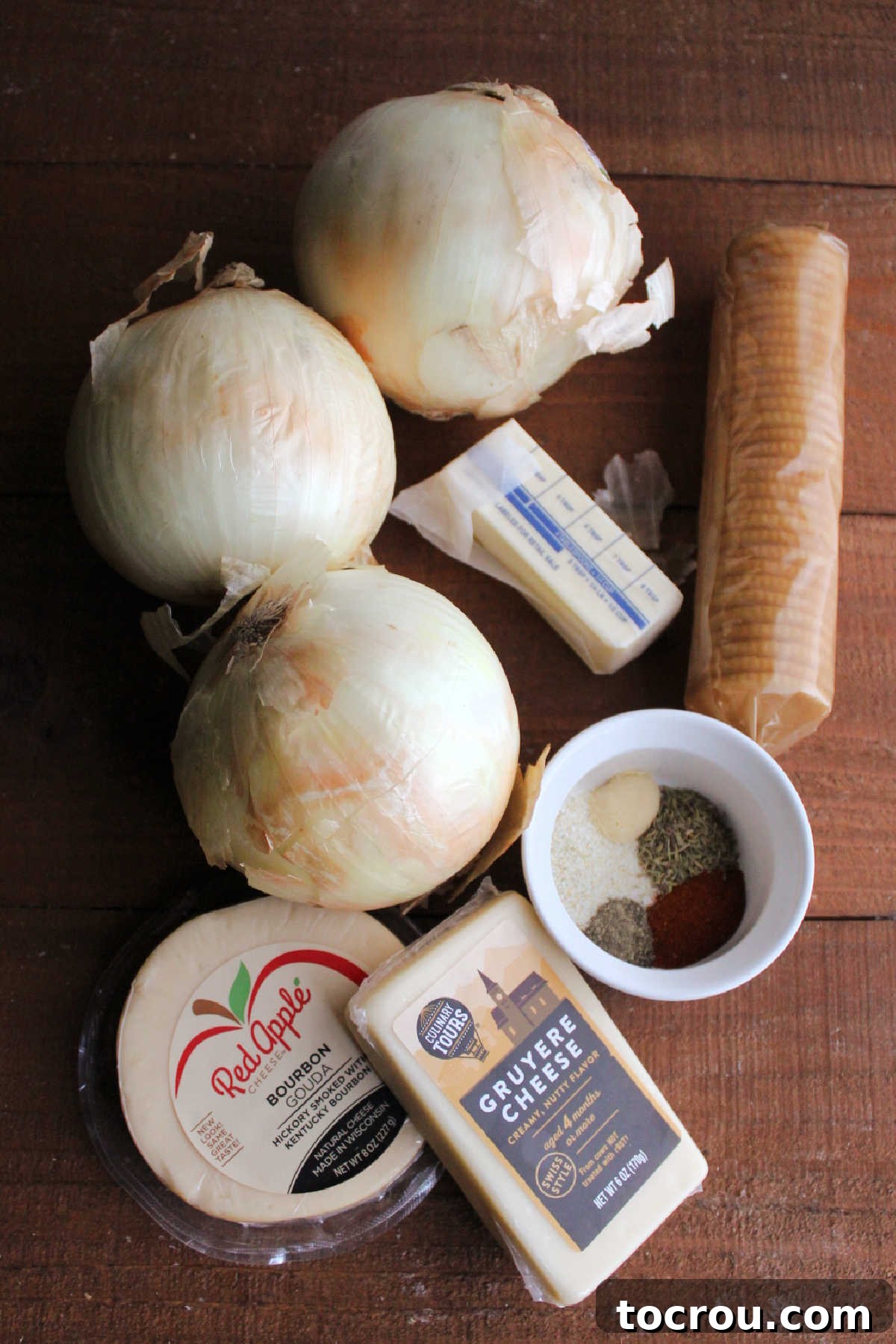 Ingredients including large sweet onions, butter, Ritz crackers, thyme, garlic salt, paprika, black pepper and cheese ready to be made into onion casserole.