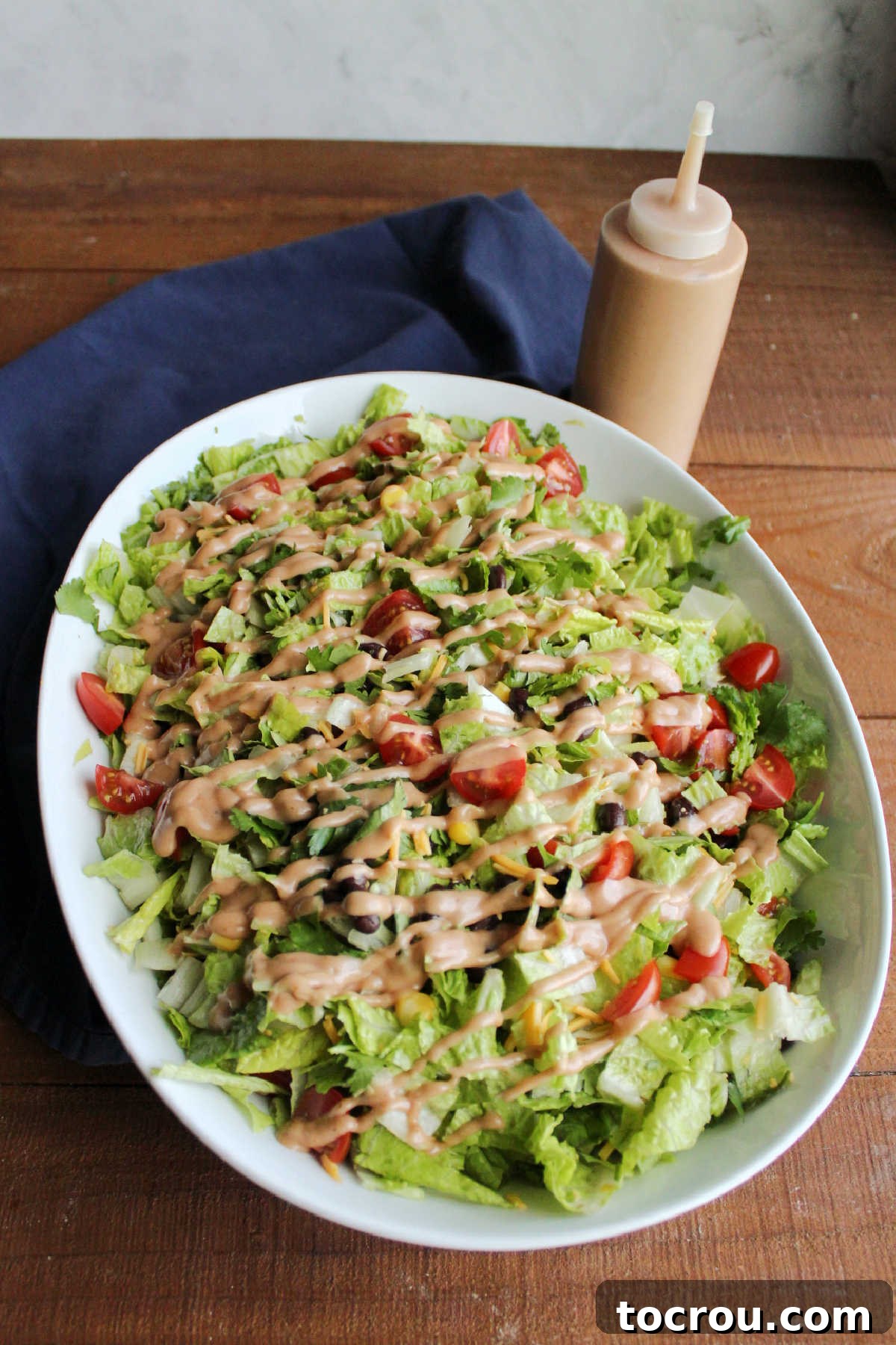 Cowboy salad topping tossed with lettuce and topped with drizzled creamy bbq dressing.