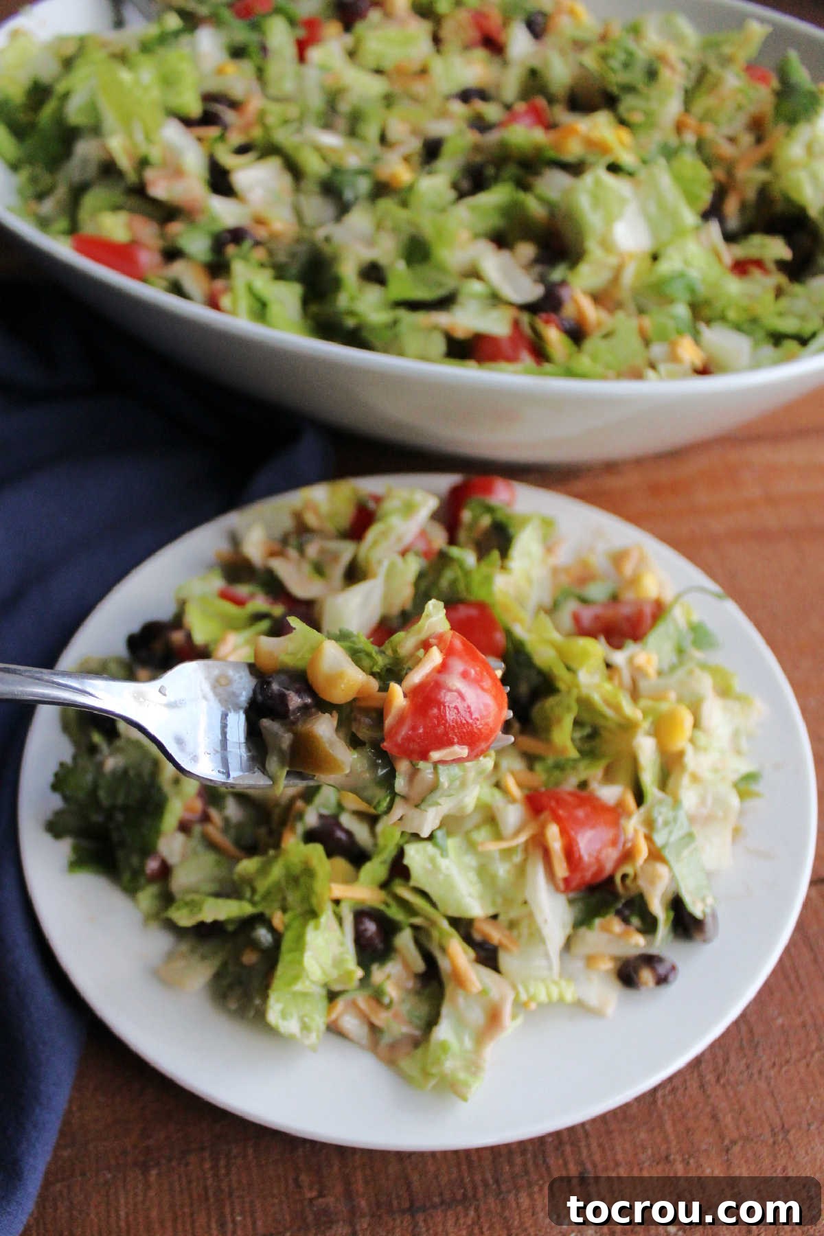 Forkful of cowboy salad with beans, tomatoes, cheese, and creamy bbq salad dressing.