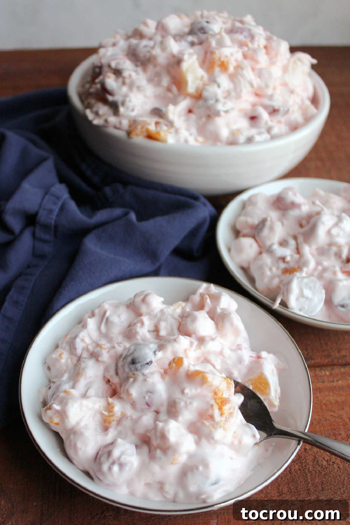 Divine Ambrosia Medley 5 Small fruit bowls filled with ambrosia showing fruit and marshmallows coated in a light pink fluffy dressing.