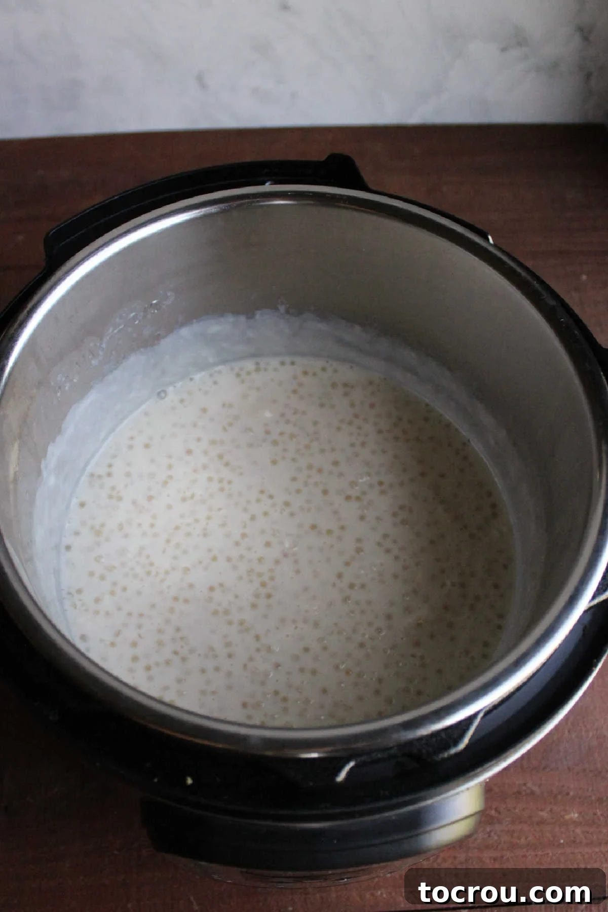 Freshly cooked tapioca pudding inside the Instant Pot, showing expanded tapioca pearls in a still somewhat liquid, milky mixture.