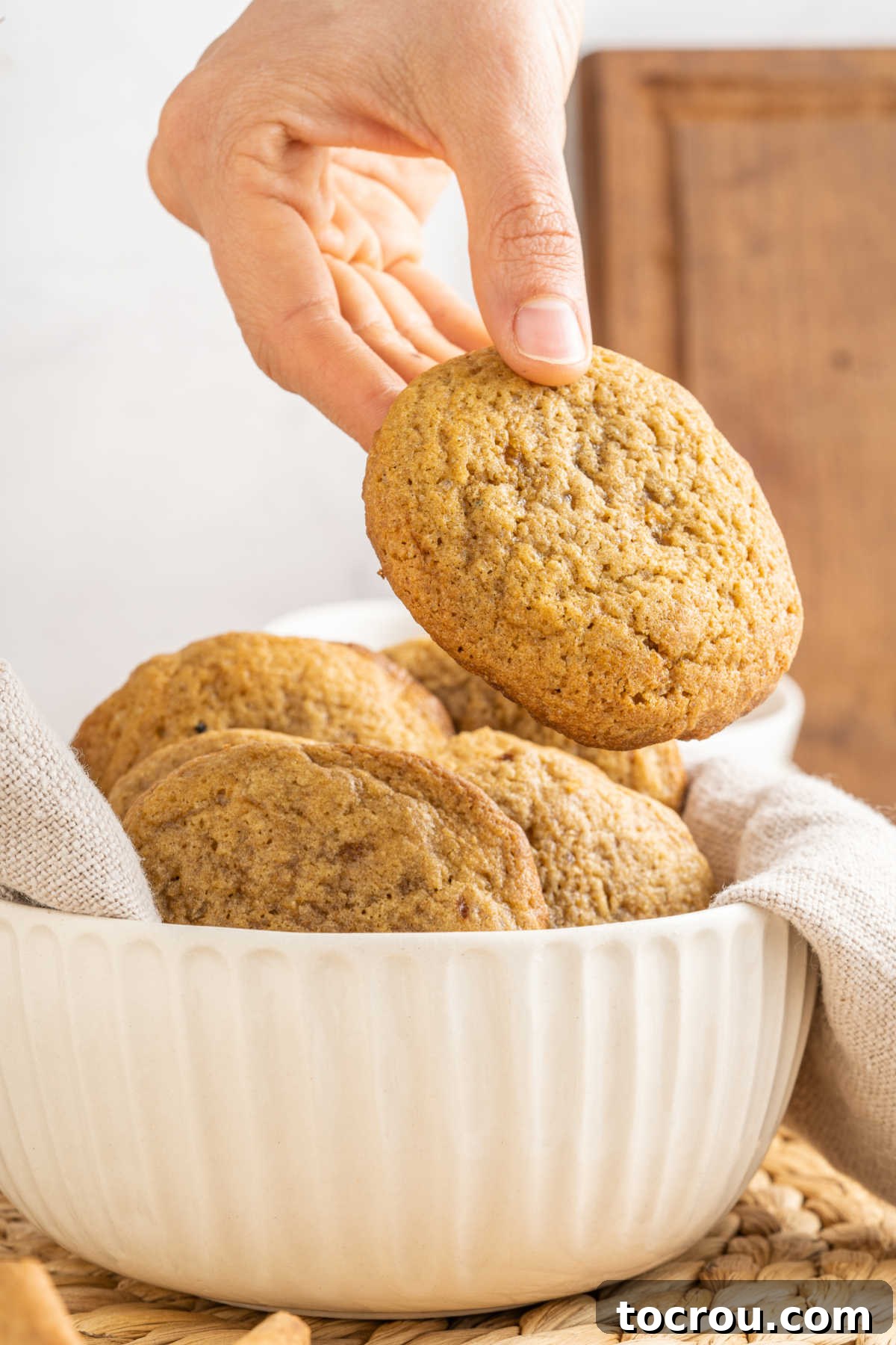 Hand holding large chai spiced cookie, ready to eat.