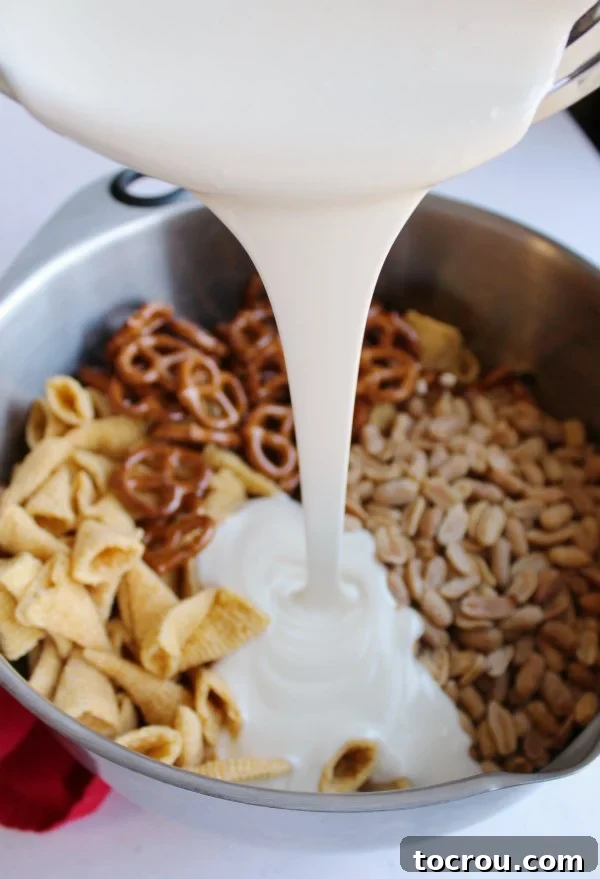 pouring melted white chocolate over pretzels, peanuts, bugles etc.