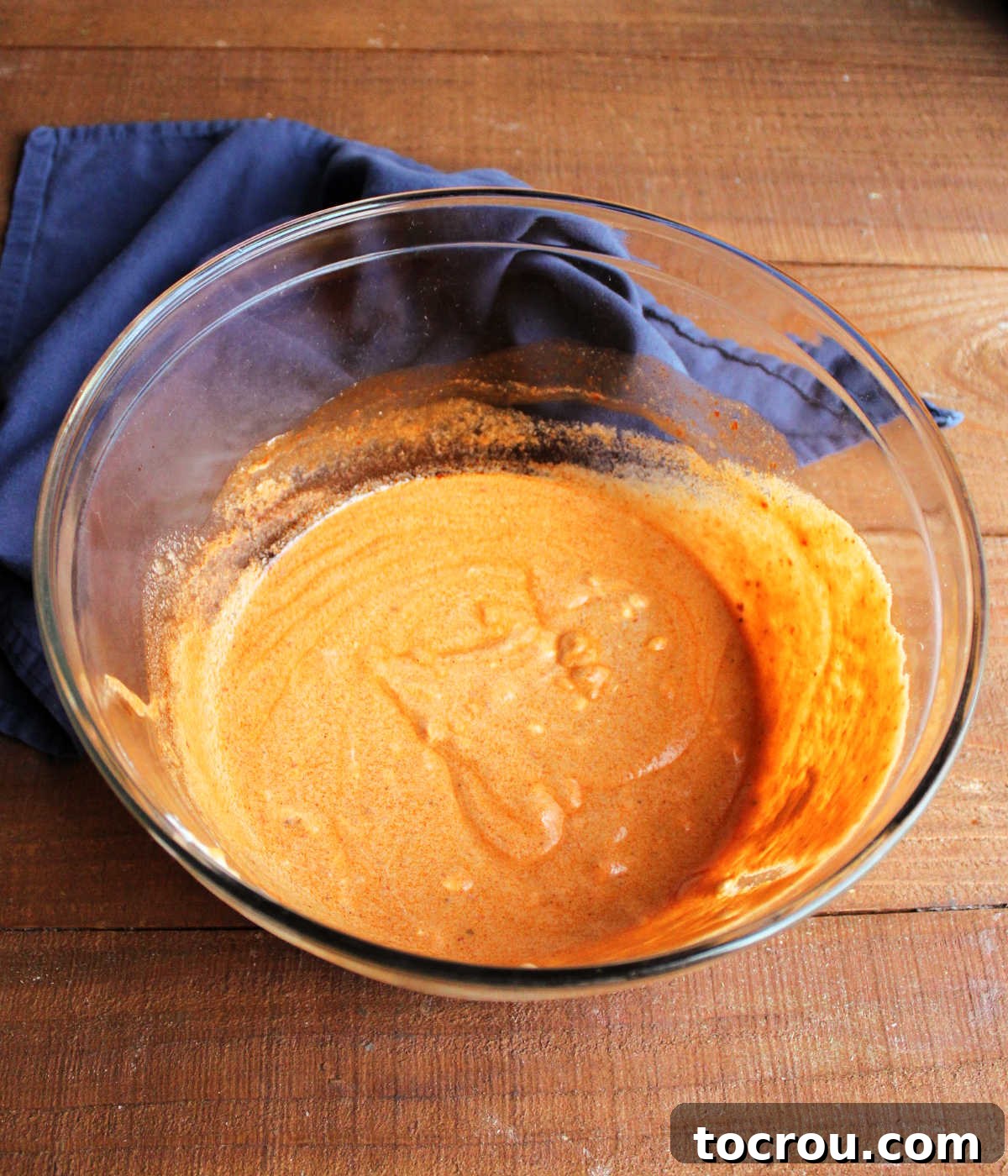 Mixing the Creamy Enchilada Dressing A large mixing bowl containing the rich, creamy red enchilada macaroni salad dressing, beautifully prepared and ready for the other ingredients to be folded in.