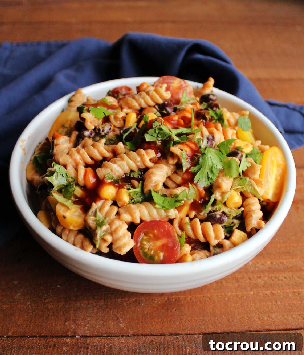 Tex-Mex Macaroni Salad Ready for Enjoyment A large serving bowl showcasing the finished Tex-Mex macaroni salad, vibrant with colors from fresh ingredients like corn, black beans, and tomatoes, all ready to be dished out and enjoyed.