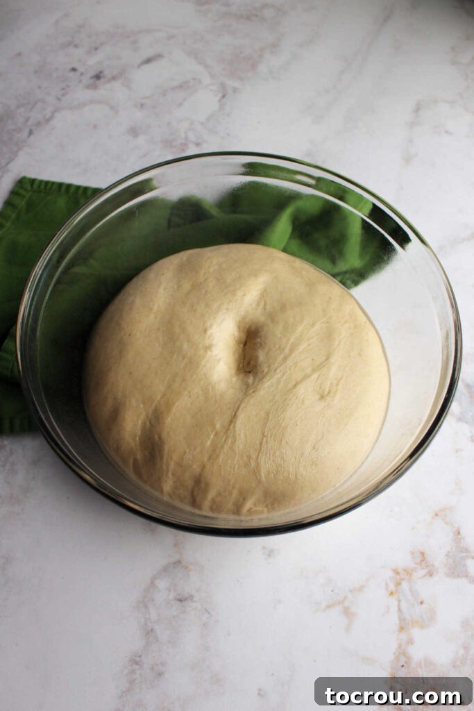 Bowl of sourdough crescent dough with a finger indent in the middle showing it is properly proved.