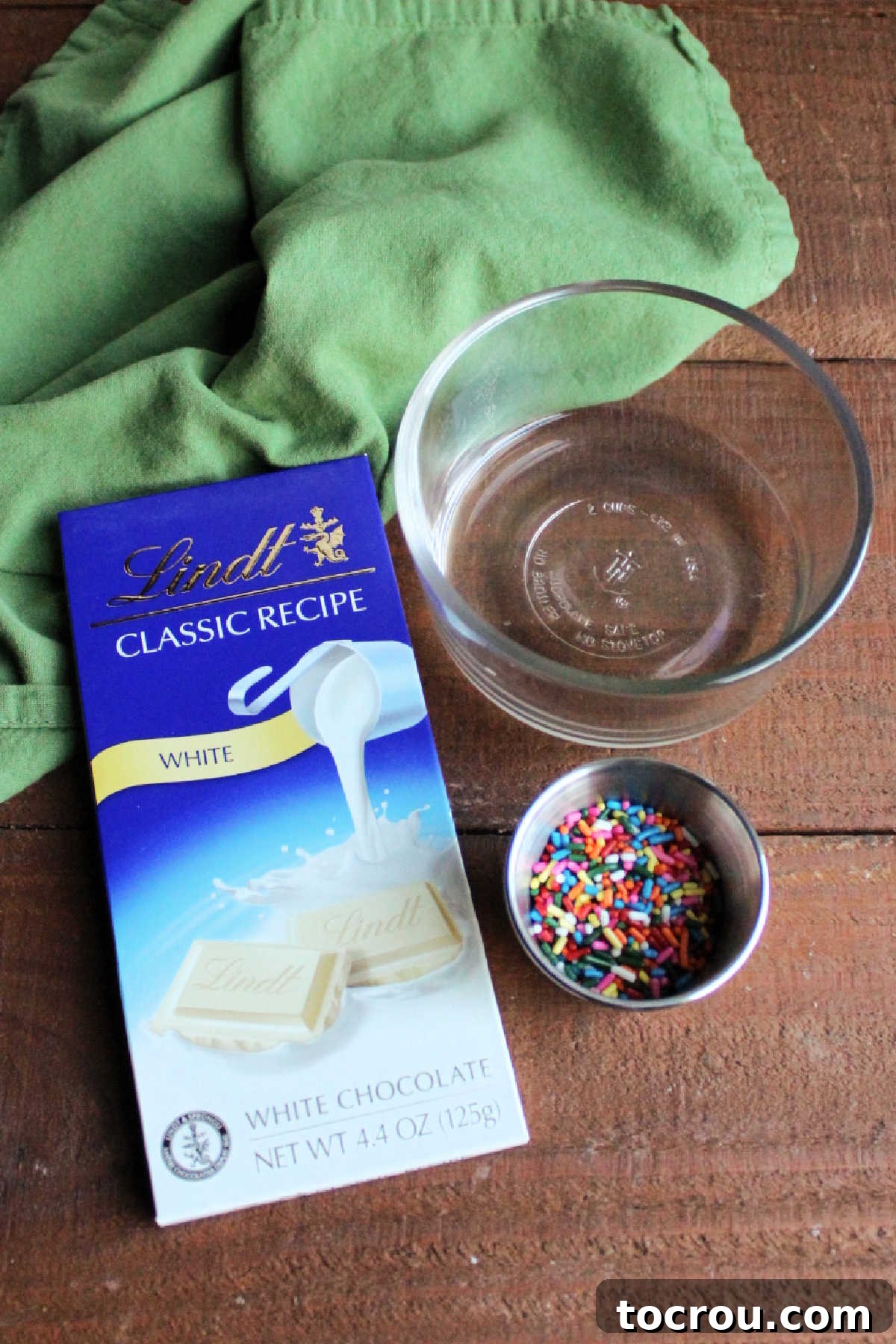 DIY Unicorn Rainbow Glaze 4 Ingredients including a white chocolate bar, melted coconut oil, and colorful sprinkles.