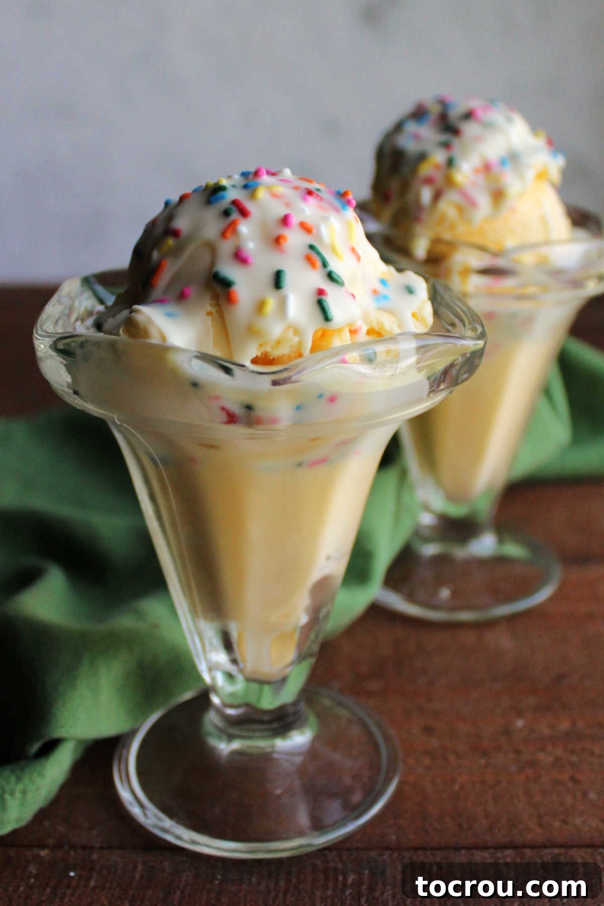 DIY Unicorn Rainbow Glaze 9 Side view of two glass sundae cups filled with vanilla ice cream topped with white chocolate and sprinkle magic shell.