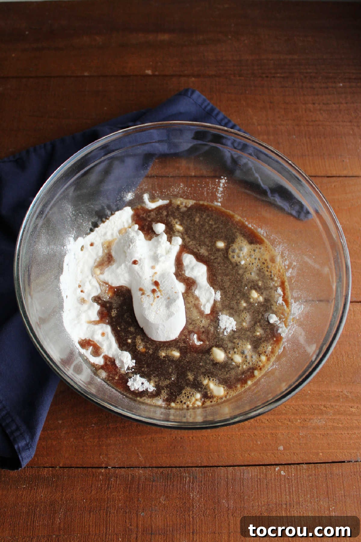 Mixing bowl filled with cake mix and water with coffee and vanilla dissolved inside.