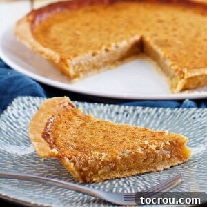 close slice of honey chess pie on plate with fork ready to eat.