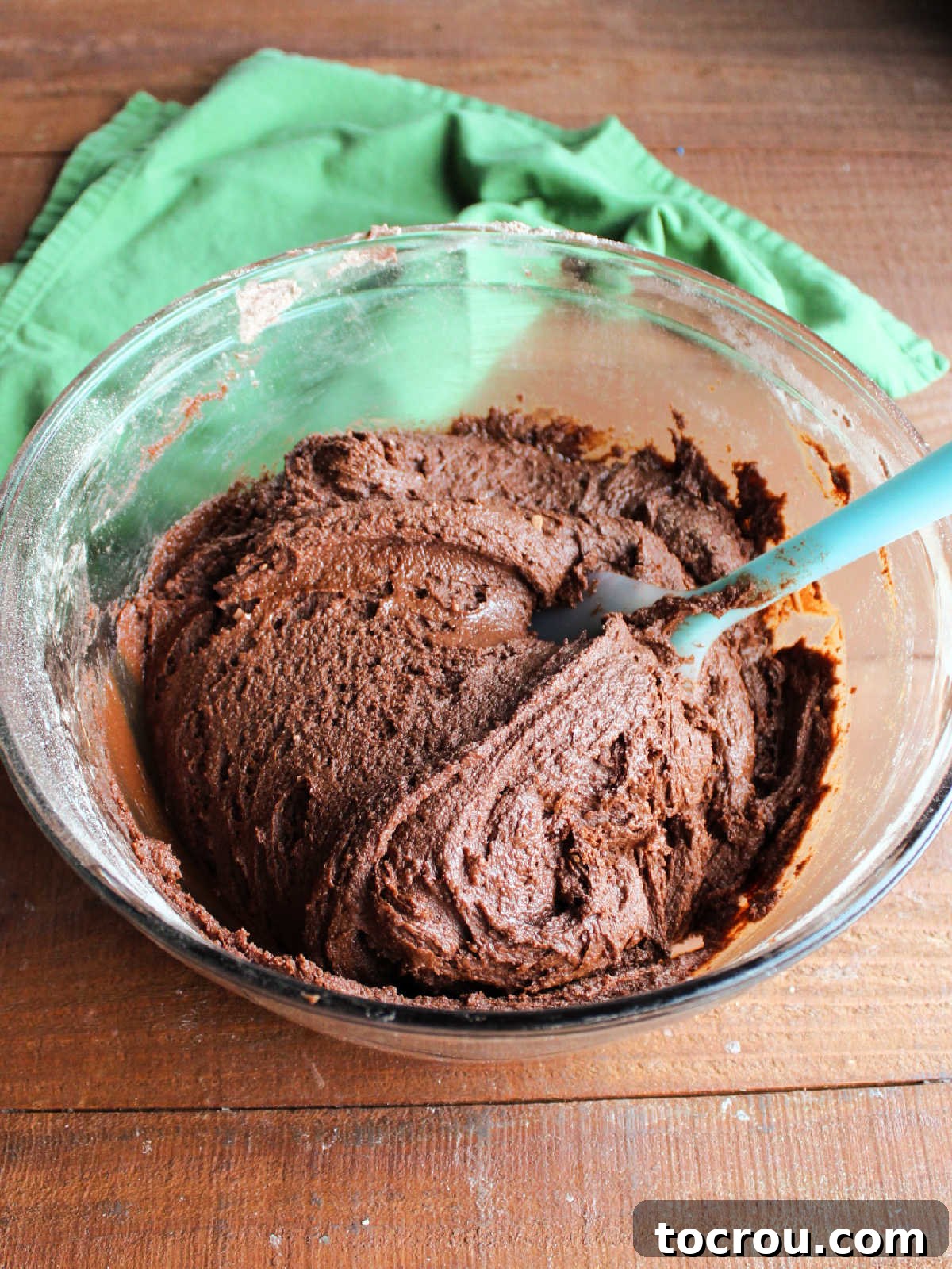 Bowl of chocolate crinkle cookie dough showing its soft texture and rich brown chocolate color.
