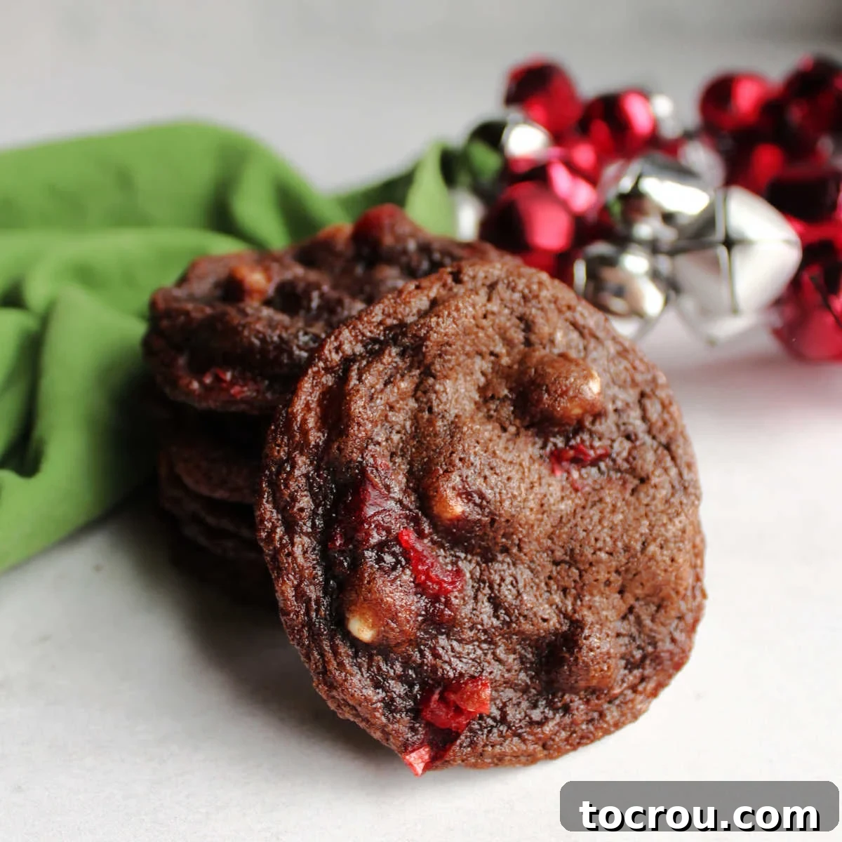 These cookies are a homage to chocolate-covered cherries, featuring rich chocolate, white chocolate chips, and maraschino cherries for a full flavor profile, topped with a luscious fudge frosting. Fudgy chocolate cookie with creamy white chocolate chips and vibrant maraschino cherry pieces baked inside.