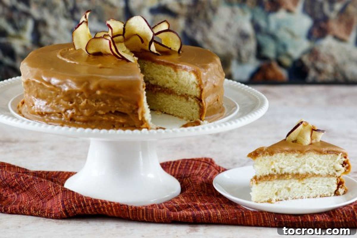Homemade Southern caramel cake on a cake stand next to a freshly cut slice of caramel cake, ready to be enjoyed.