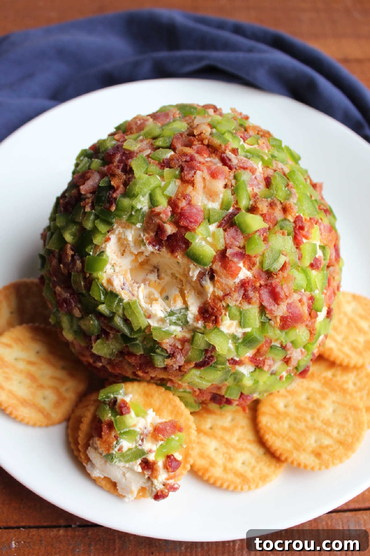 Zingy Bacon Jalapeno Cheese Ball 9 Jalapeno popper cheese ball with bacon and cheddar cheese served on plate with ritz crackers.