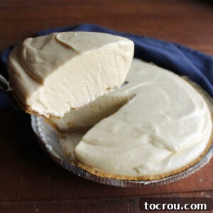 Lifting slice of creamy orange pie out of graham cracker crust.