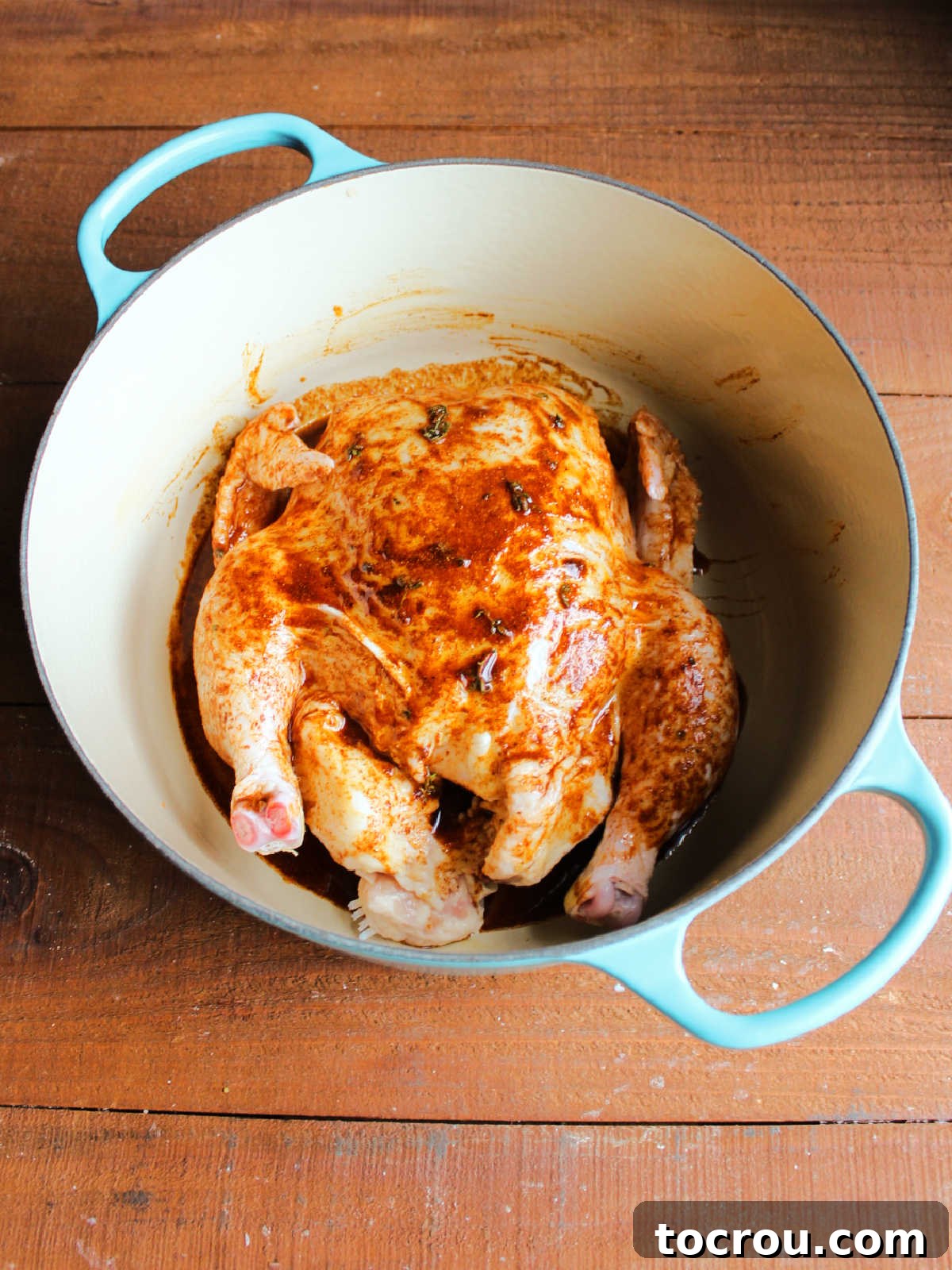 Seasoned oil and lemon juice mixture rubbed all over the raw chicken in an enamled cast iron dutch oven.