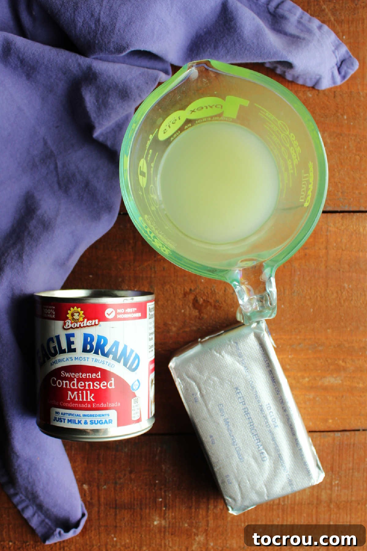 Ingredients including lemon juice, cream cheese, and sweetened condensed milk ready to be made into frosting. 