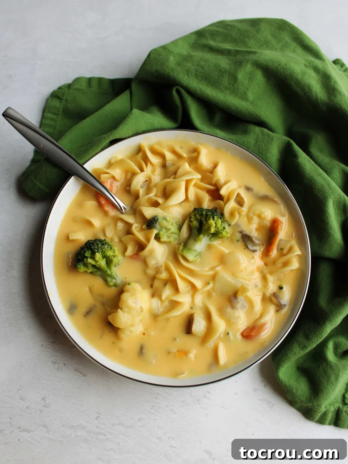 Grandma's Copycat Kelly's Cheese Soup Bowl of creamy Velveeta cheese soup loaded with pasta, vegetables, and more, a comforting meal.