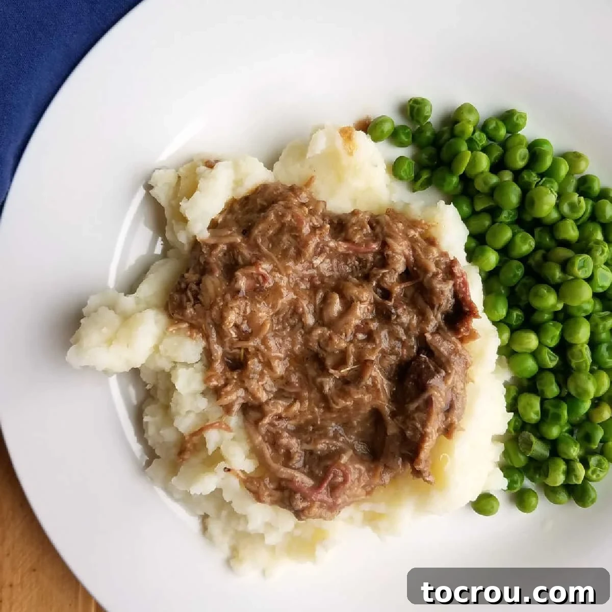 Balsamic Rosemary Braised Pork Butt Recipe Shredded balsamic braised pork served on a bed of creamy mashed potatoes with green peas.