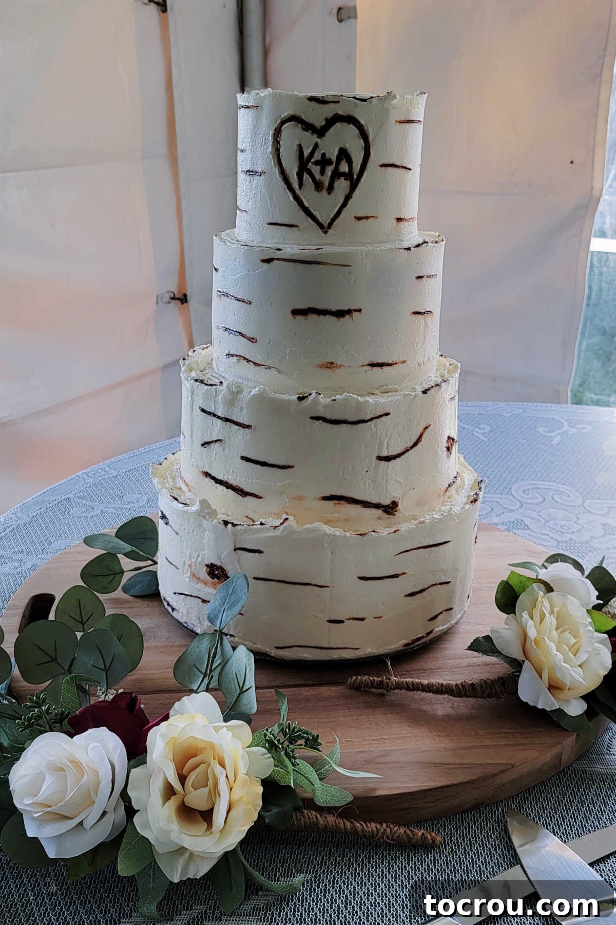 The 10-Inch Vanilla Classic 3 4 tier vanilla cake with white vanilla buttercream decorated with brown stripes to make it look like birch bark.