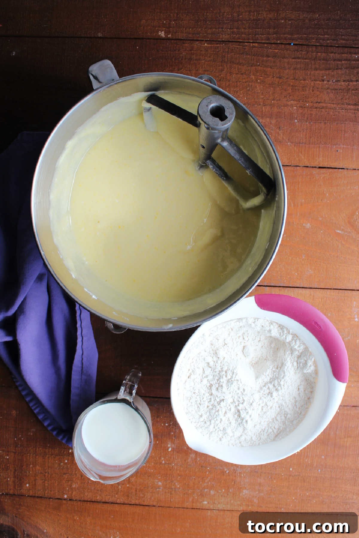 The 10-Inch Vanilla Classic 7 Mixer bowl with butter, sugar, oil, egg mixture next to bowl with dry ingredients and a measuring cup with milk ready to be made into vanilla cake batter.