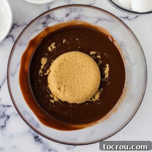 Adding brown sugar to melted butter and chocolate chip mixture.